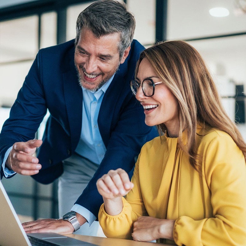 Law clerk and lawyer smiling working on laptop