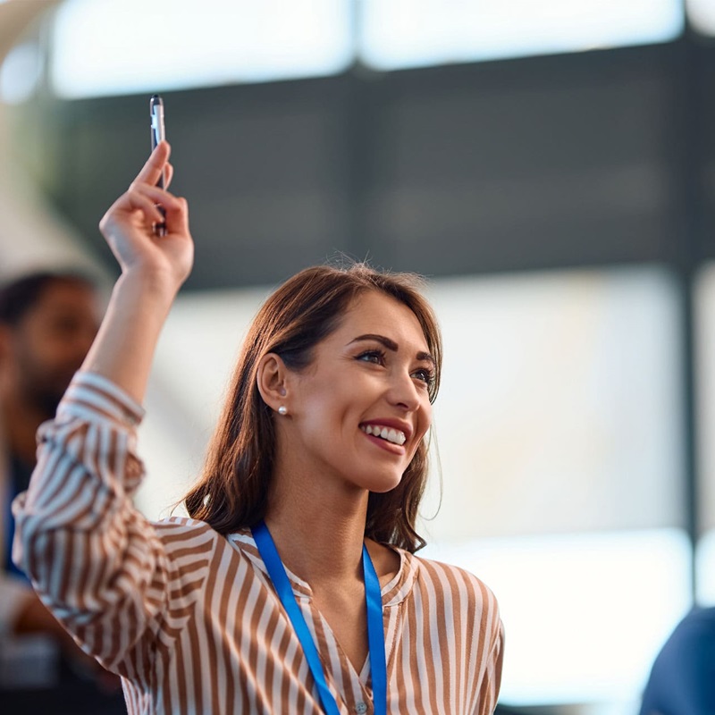 Woman answering question with hand raised